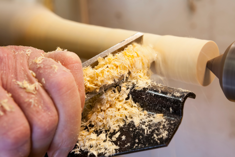 a person using a lathe making chips